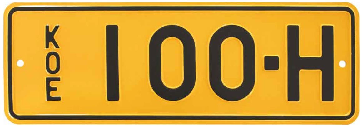 Koenumerokilpi, keltapohjainen metallilevy, jossa mustat kohokirjaimet ja -numerot 'KOE 100-H'. Kilven vasemmassa reunassa pystysuuntainen 'KOE'-merkintä.