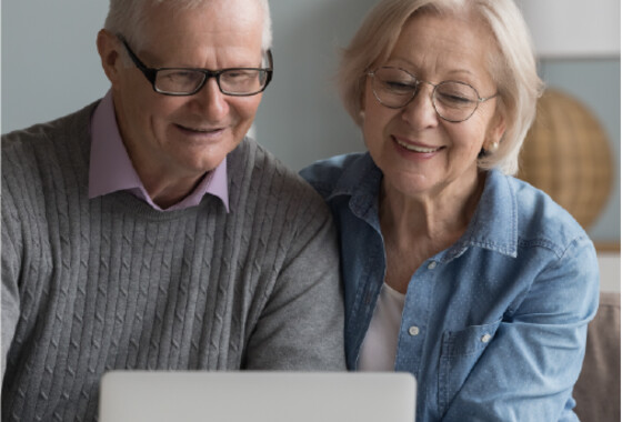vanhempi pariskunta katsoo tietokoneen näyttöä.