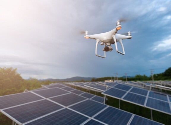 Dronea lennätetään aurinkokennokattojen yläpuolella.